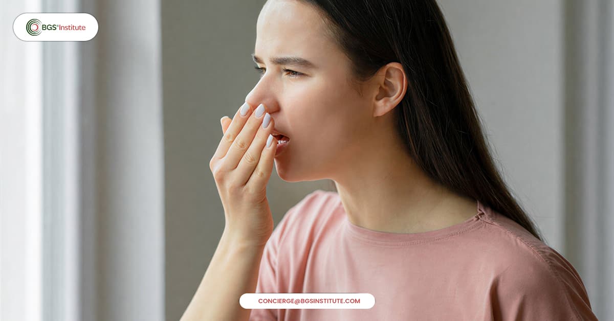 Woman checking persistent bad breath by covering her mouth with her hand